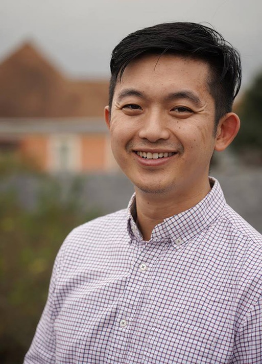 Dr. Li outside smiling in a plaid shirt