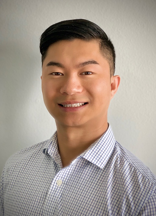Dr. Peng inside smiling in a plaid shirt