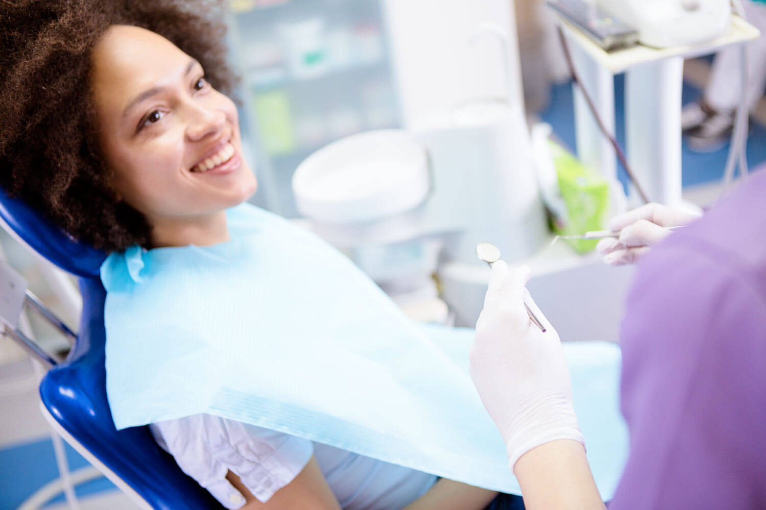 Brunette woman at the dentist in Katy, TX, smiles before receiving preventive dental care